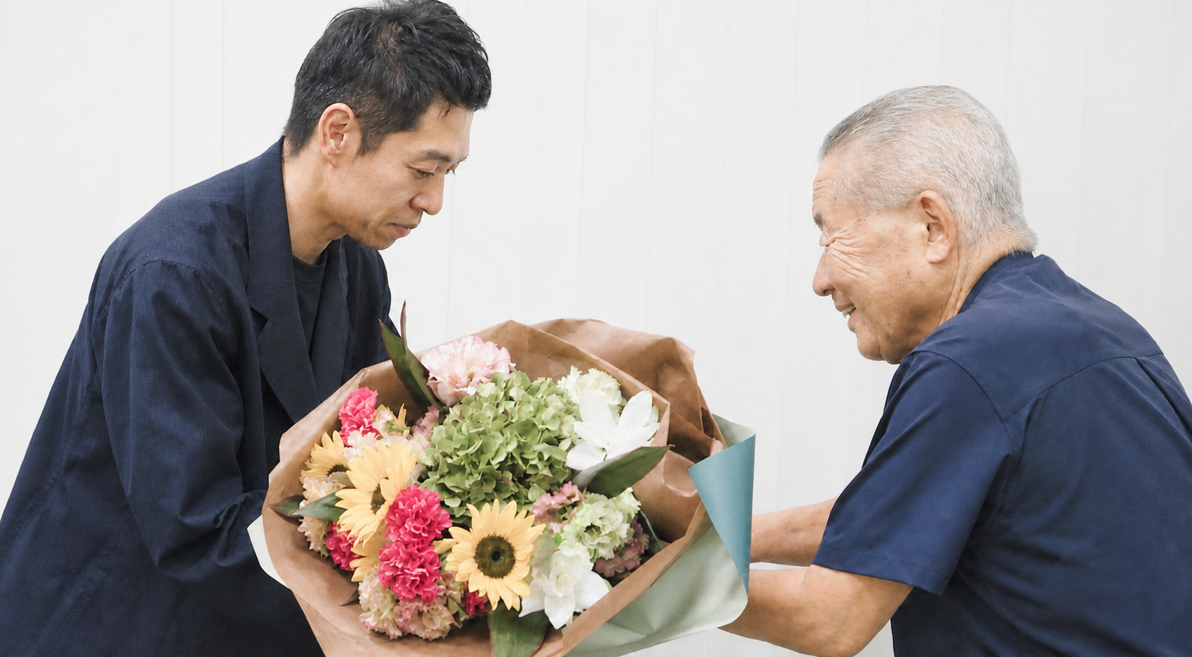 事業承継を終えた経営者へ花束を贈る様子